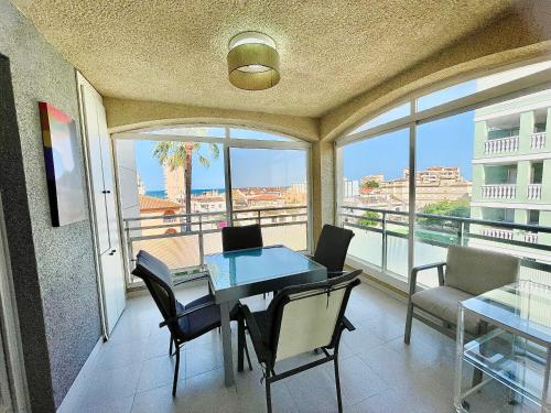 comedor con mesa y sillas y balcón en Apartamento con Piscina 3 habitaciones, en Sueca