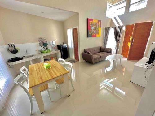 a living room with a table and chairs and a couch at Batujai House in Praya