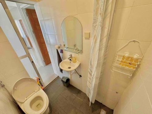 a small bathroom with a toilet and a sink at Batujai House in Praya