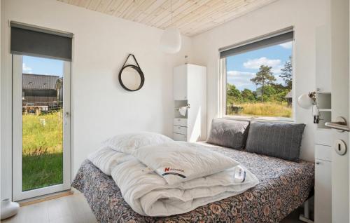 a bedroom with a large bed with a large window at Nice Home In Sams With Kitchen in Nordby