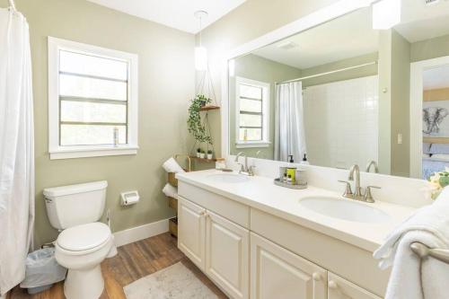 y baño con aseo, lavabo y espejo. en Charming townhome w/ private backyard & fire pit, en Palm Beach Gardens