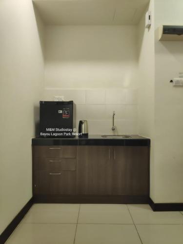 uma cozinha com um lavatório e um micro-ondas em M&M Studiostay at Bayou Lagoon Park Resort em Malaca