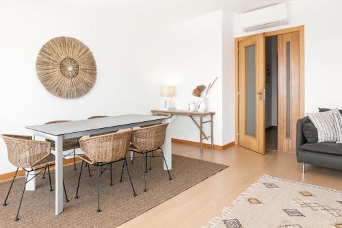 a dining room with a table and chairs and a couch at Terraço da Formosa in Silveira