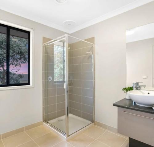 ein Bad mit einer Glasdusche und einem Waschbecken in der Unterkunft Deluxe Double Room with private shower in Point Cook