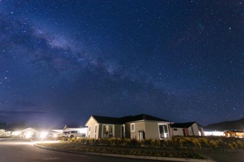 ein Haus unter einem Sternenhimmel in der Nacht in der Unterkunft Snowflake Tekapo in Lake Tekapo