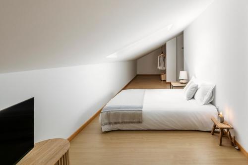 a bedroom with a white bed and a staircase at Terraço da Formosa in Silveira