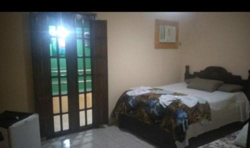a bedroom with a bed in a room with a window at POUSADA BRASIL RECIFE in Recife