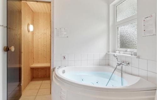 a bath tub in a bathroom with a window at Stunning Home In Hadsund With 3 Bedrooms, Sauna And Wifi in Odde