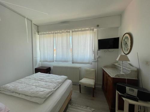 une petite chambre avec un lit et un bureau dans l'établissement Arcachon: Appartement T2 avec Accès Direct à la Plage, Terrasse et Parking Privé - FR-1-474-59, à Arcachon