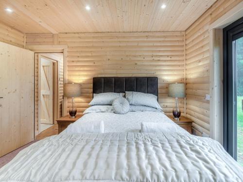 um quarto com uma cama grande e 2 candeeiros em Alpaca Lodge em Barkston