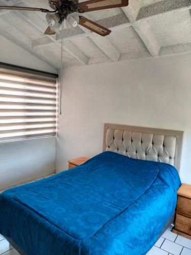 a bedroom with a blue bed and a ceiling at Casa Lili in Cuernavaca