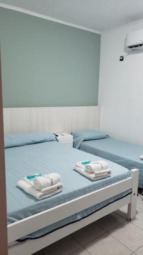 a bedroom with two beds with towels on them at Hotel Riberas San Nicolas in San Nicolás de los Arroyos