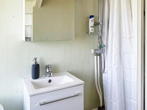 a bathroom with a sink and a shower curtain at Holiday home FÄRGELANDA VI in Färgelanda