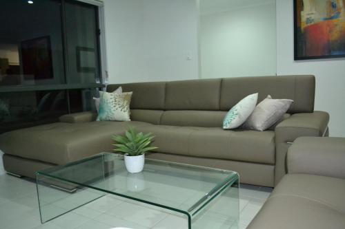 - un salon avec un canapé et une table basse en verre dans l'établissement The Haven Biloela, à Biloela