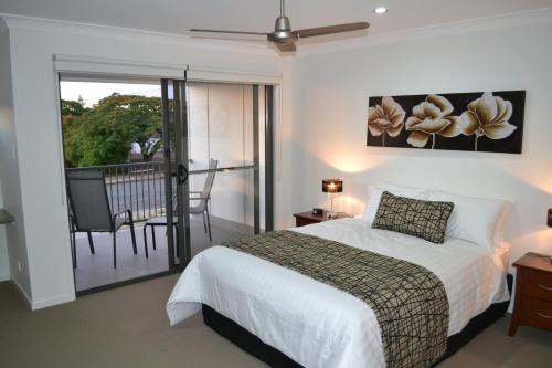 a bedroom with a bed and a balcony at The Haven Biloela in Biloela