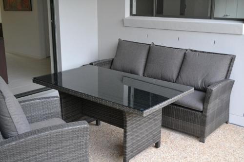 a glass table and two chairs in a room at The Haven Biloela in Biloela