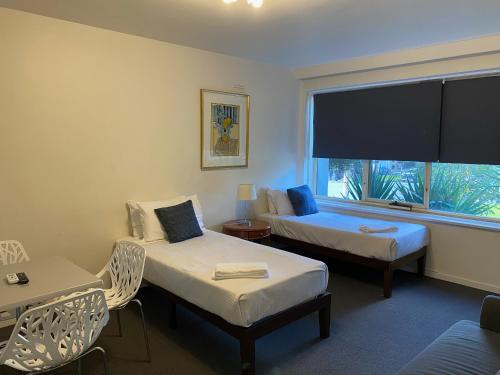 a hotel room with two beds and a large window at City Edge East Melbourne Apartment Hotel in Melbourne