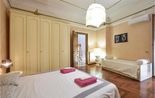 Stunning Home In Palazzolo Acreide With Kitchen في بالاتسولو أكريدي: غرفة نوم بها سرير وفوط وردية اللون