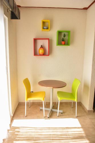 a table and two chairs and a table and some pictures at Suites Los Arcos in Isla Mujeres