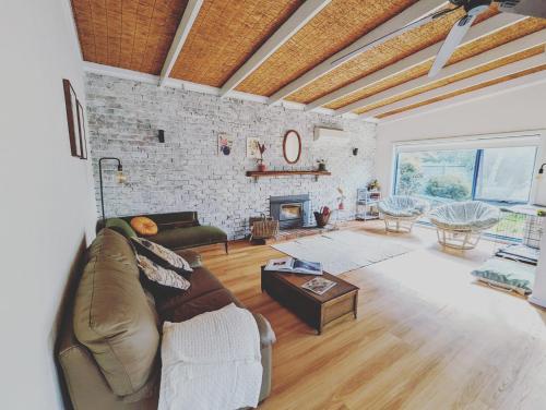 a living room with a couch and a fireplace at Cosy Brick Beachouse - ALL INCLUDED in Inverloch