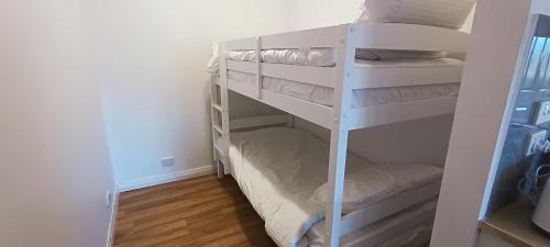 a white bunk room with white bunk beds at The Berri Bubble Lodge in Berridale