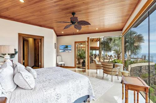 1 dormitorio con 1 cama y ventilador de techo en Villa Dos Playas, en Playa Hermosa