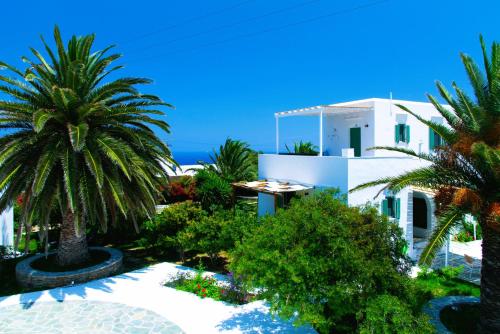 a view of a white building with palm trees and the ocean at ANCIENT MEROPIA - Les jardins des muses in Apollonia
