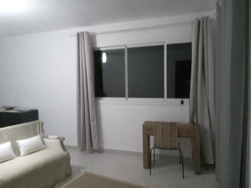 ein Wohnzimmer mit einem Sofa, einem Tisch und einem Fenster in der Unterkunft Suite parentale Villa au bord de la mer chez Saloua in Bouéni