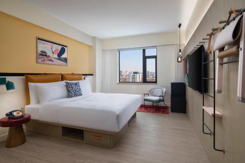 a hotel room with a bed and a tv at Moxy Xi'an Beilin in Xi'an