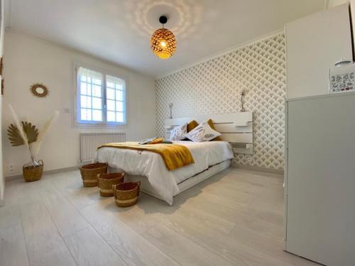 a white bedroom with a bed and baskets in it at Chambre cosy RDC avec véranda, jardin privé et wifi, proche plage – Saint-Michel-Chef-Chef - FR-1-306-1256 in Saint-Michel-Chef-Chef