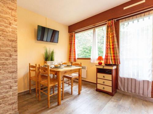 une salle à manger avec une table, des chaises et des fenêtres dans l'établissement Studio 4 pers à Saint Lary avec Wifi gratuit, balcon sud, jacuzzi, salle de gym, sauna et parking - FR-1-296-470, à Vignec