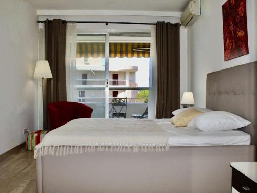 une chambre avec un grand lit blanc avec une fenêtre dans l'établissement Appartement 2P. avec vue mer et climatisation, Villeneuve-Loubet Plage - FR-1-252A-107, à Villeneuve-Loubet