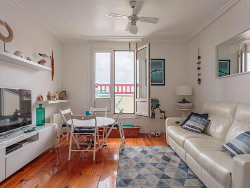 un salon avec un canapé et une table dans l'établissement Appartement moderne à 75m de la plage avec balcon et wifi - FR-1-2-433, à Hendaye