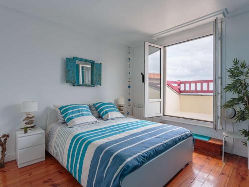 une chambre avec un lit et une grande fenêtre dans l'établissement Appartement moderne à 75m de la plage avec balcon et wifi - FR-1-2-433, à Hendaye