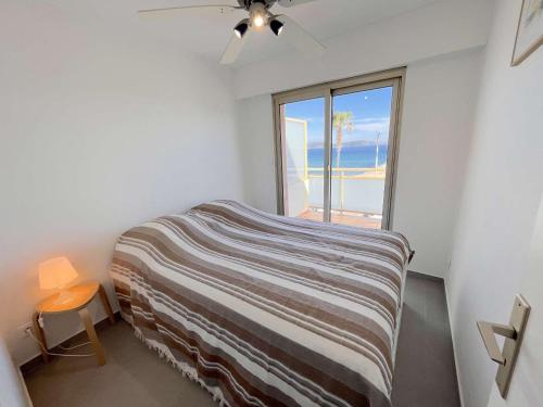 une chambre avec un lit avec une grande fenêtre dans l'établissement Appartement moderne 2 pièces avec clim, parking à Cavalaire - FR-1-226B-164, à Cavalaire-sur-Mer
