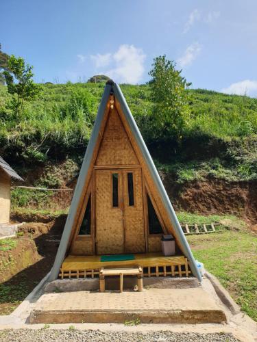 a frame house with a bench and a table at Kancah Nangkub in Pengalengan