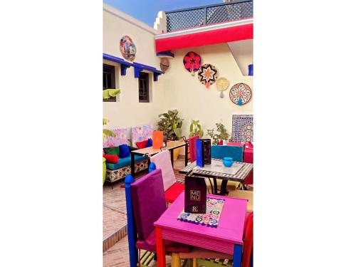 a restaurant with colorful tables and chairs on a patio at Riad Eva in Marrakesh