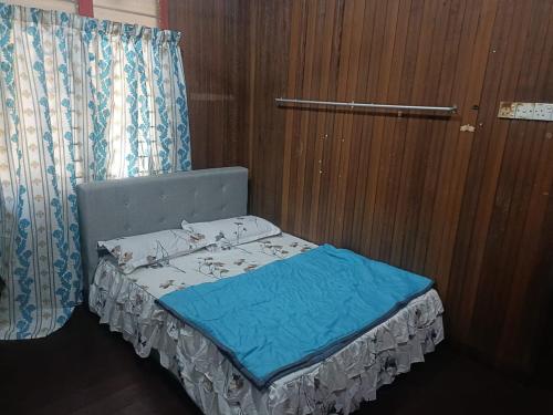 uma pequena cama num quarto com uma cortina em RS HOMESTAY DUNGUN em Kampong Pak Sabah