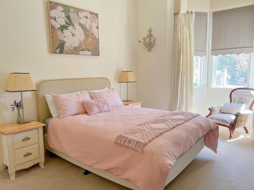 a bedroom with a pink bed and a window at The Monarch Tumut - Luxury in the valley in Tumut