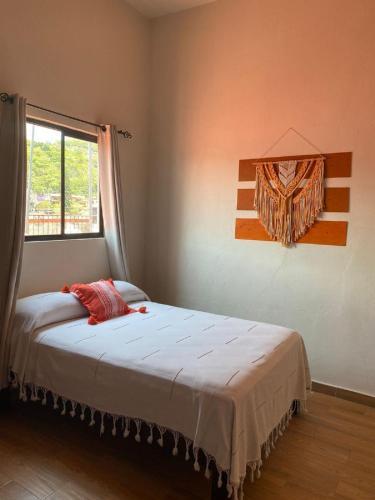 a bedroom with a large bed with a window at Grann Posada Xilitla in Xilitla