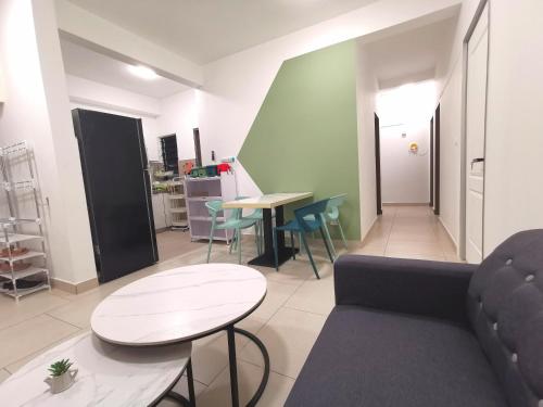 a living room with a couch and a table and chairs at Astetica 3 Bedrooms in Seri Kembangan