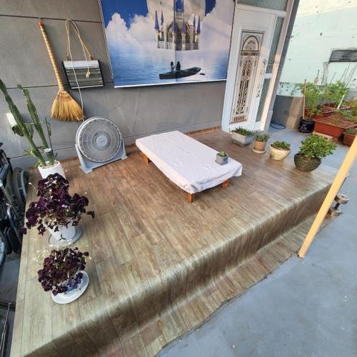 a bed on a wooden floor with potted plants at JUN house - Foreign Only in Busan