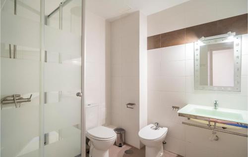 a white bathroom with a toilet and a sink at Beautiful Apartment In Cabo De Gata With 2 Bedrooms And Outdoor Swimming Pool in El Cabo de Gata
