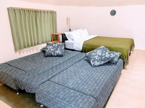 2 camas en una habitación de hotel con almohadas en Dome Planet Ocean's Seven / Vacation STAY 73132, en Teruma