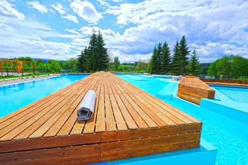 a large swimming pool with a wooden deck on top of it at Klostermann Wellness&Spa in Frymburk