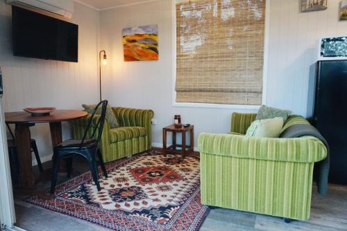 a living room with two chairs and a table at Palmyra B&B in Rainbow Flat