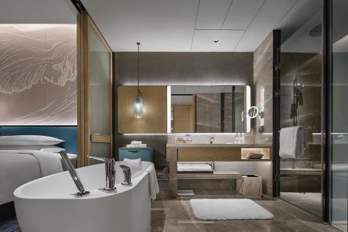 y baño con bañera, aseo y lavamanos. en Qinhuangdao Marriott Resort, en Qinhuangdao