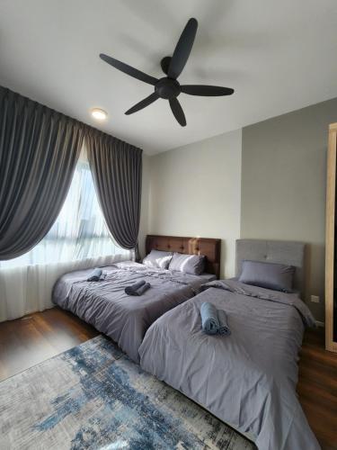 a bedroom with two beds and a ceiling fan at Sunway onsen suite ipoh in Ipoh