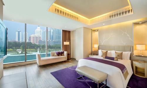 天津市にあるザ セント レジス テンシンの大きなベッドと大きな窓が備わるホテルルームです。
