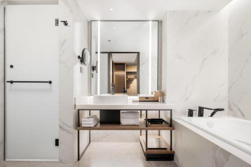 a white bathroom with a sink and a mirror at Sheraton Chengdu Lido Hotel in Chengdu